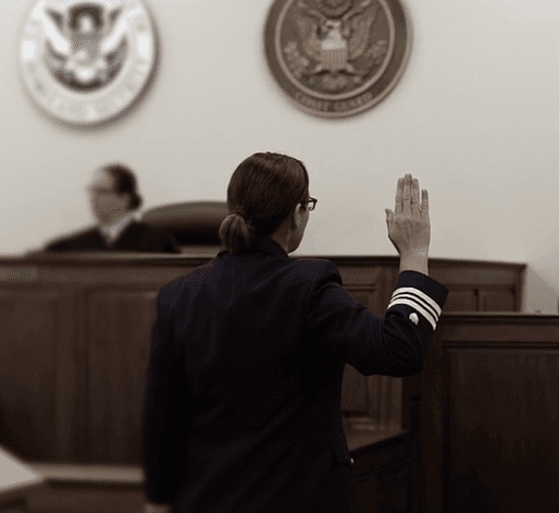 A Coast Guard lawyer taking an oath in a courtroom